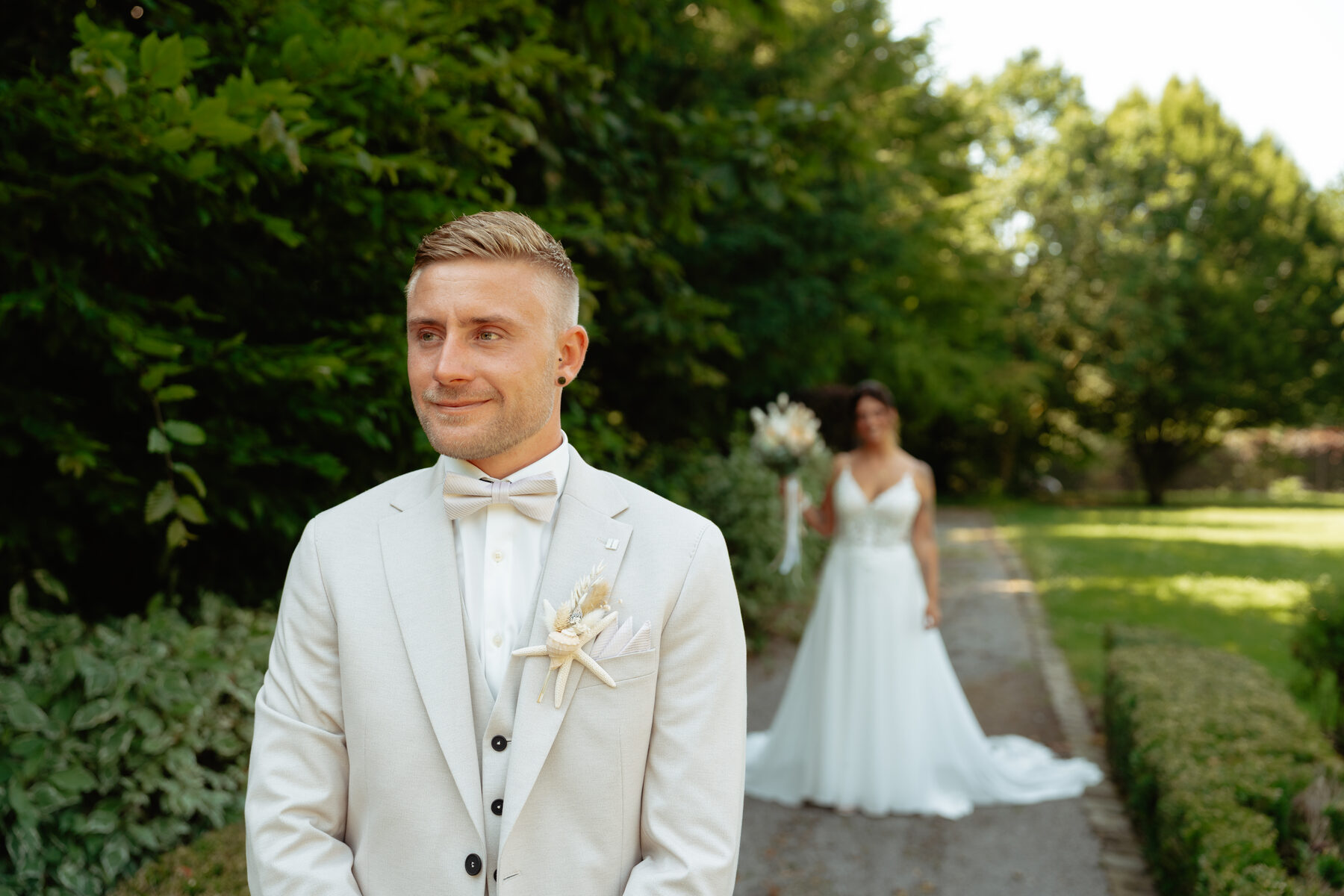 Le marié en costume clair, boutonnière en étoile de mer